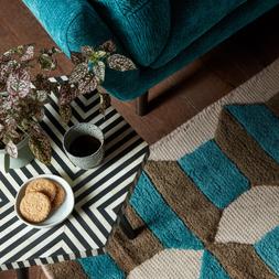 Hygge 2 Seater in Heavy Textured Chenille Teal with Dark Wood Feet, £899. The Fitzrovia Designer Footstool in The Fitzrovia Matt Velvet Black All Over, £349